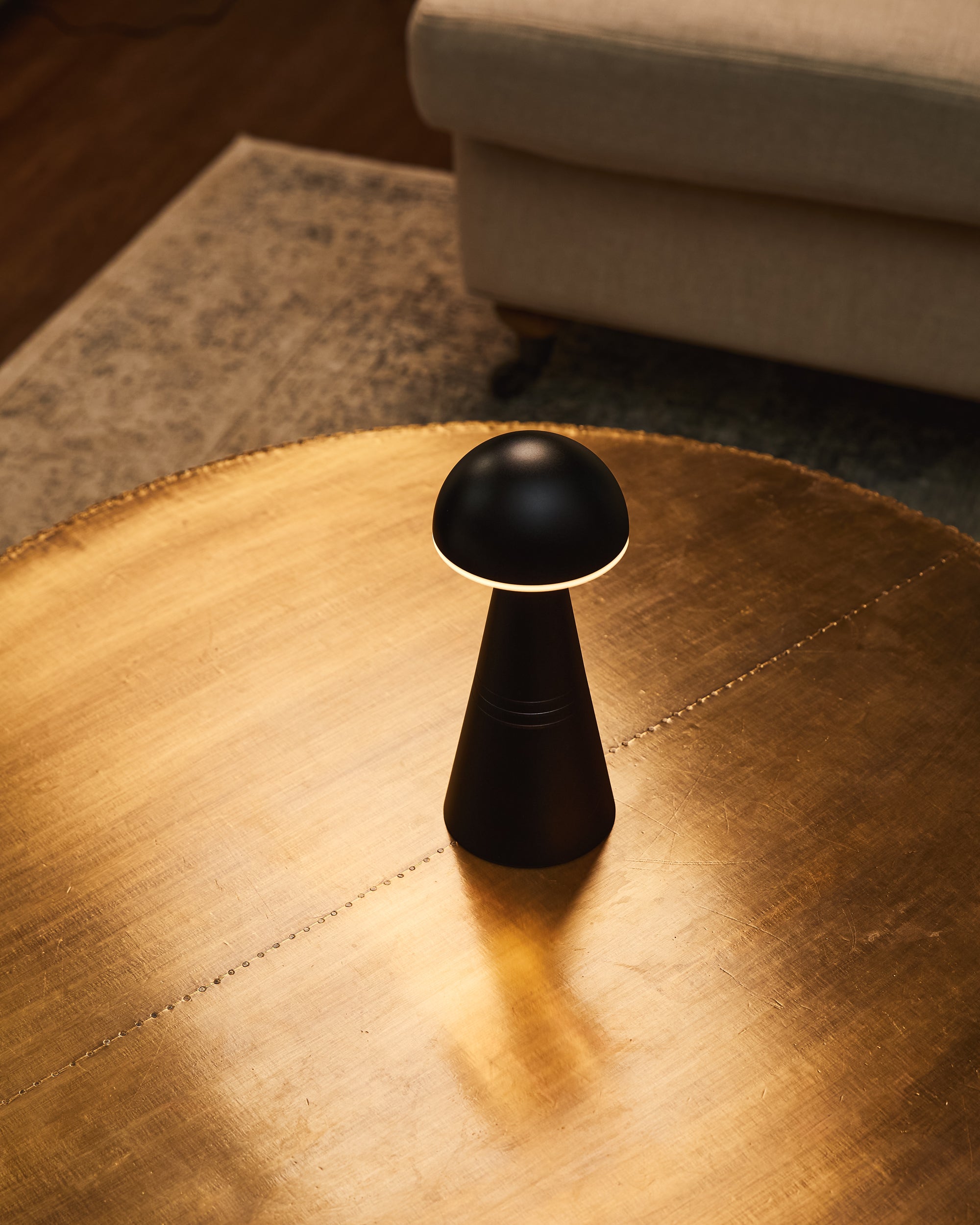 A black cordless table lamp in a cosy home setting.