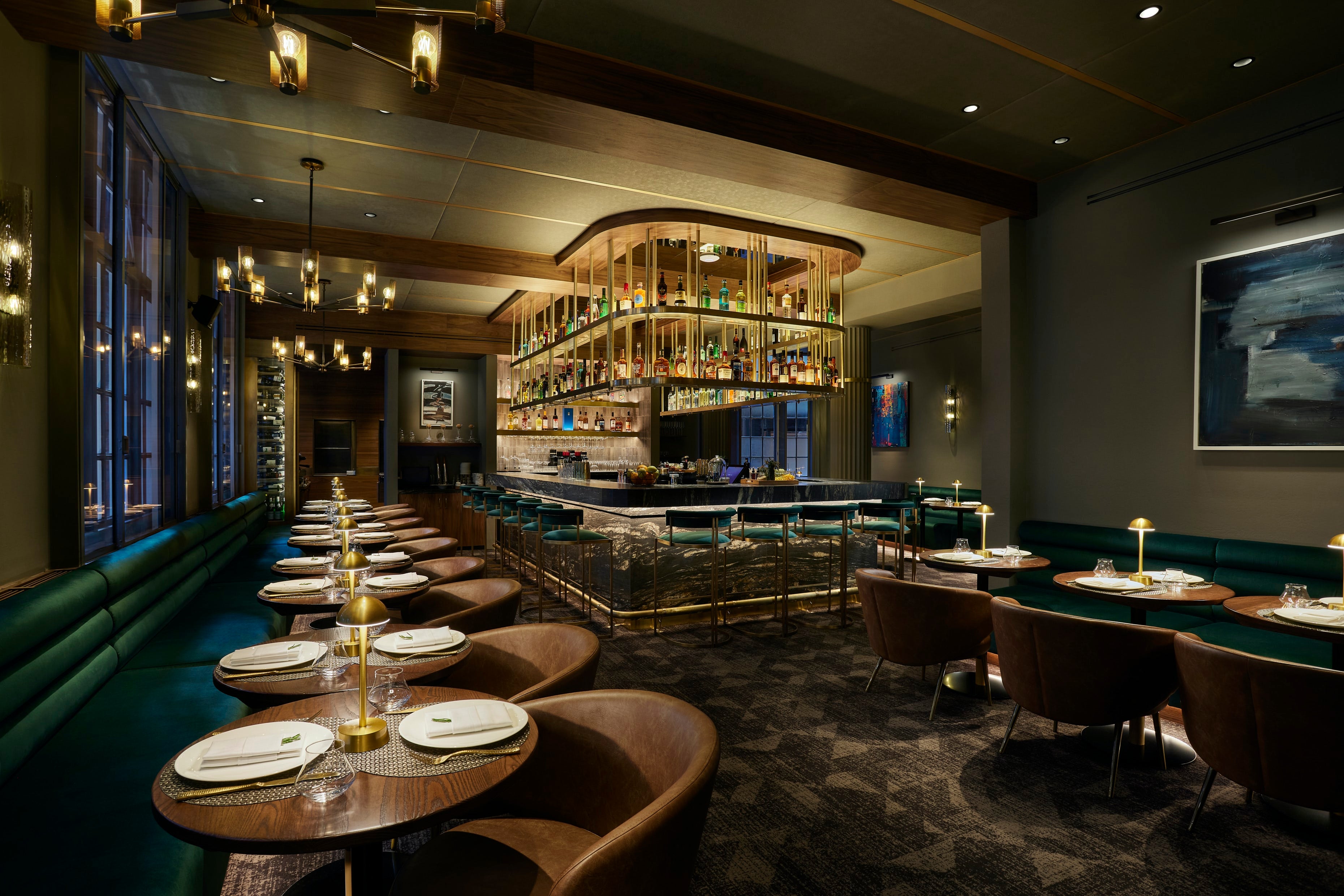 Modern restaurant interior with cordless table lamps on tables, brown chairs, and a high class bar area.