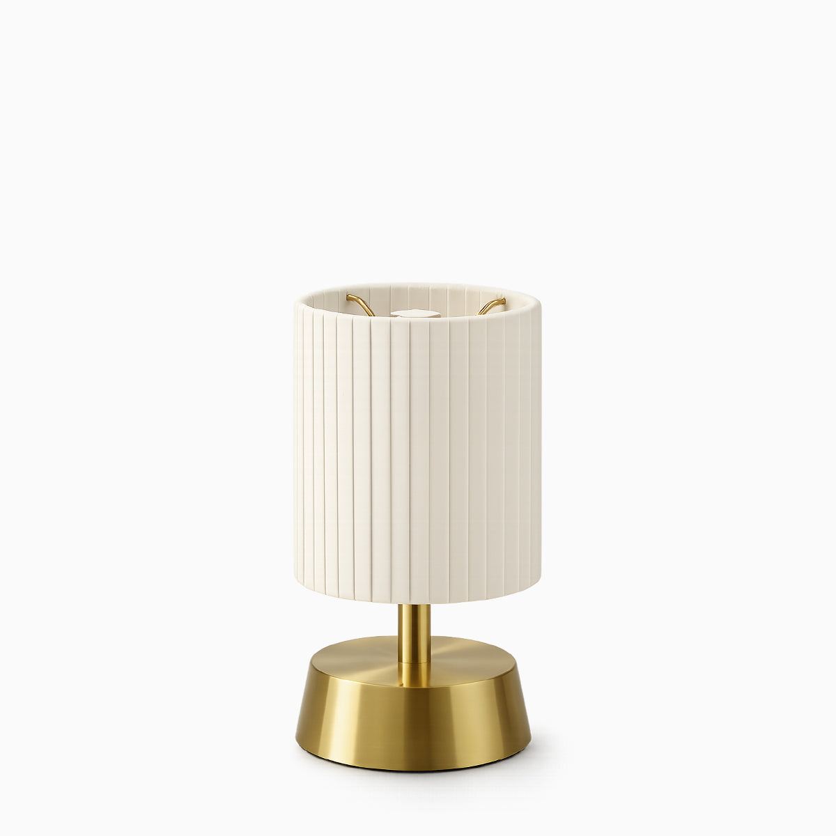 Cordless table lamp with ivory pleated shade and brass base on a white background