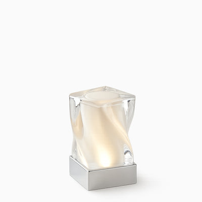 Modern glass cordless lamp with a soft glow on a white background