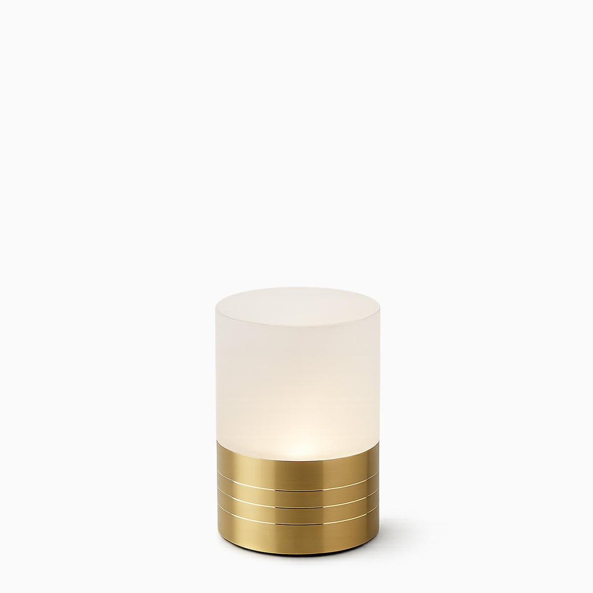 Small cylindrical cordless lamp with frosted shade and gold base on a white background