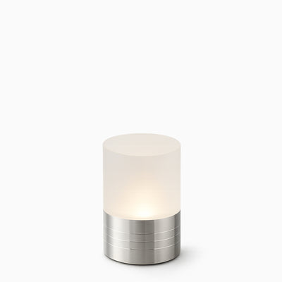 Small cylindrical cordless light with frosted glass shade and metallic silver base on a white background