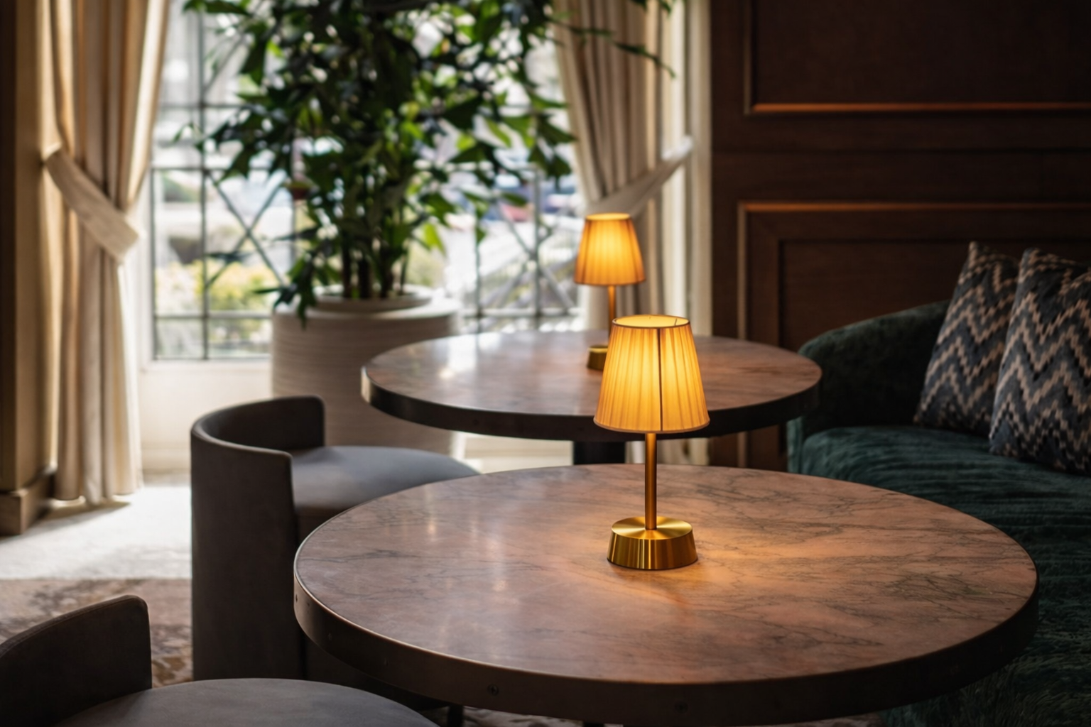 Modern interior with round wooden tables, chairs, and decorative fabric shade cordless table lamps.