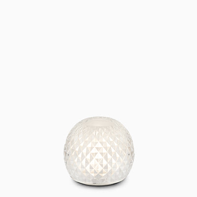 A glass spherical cordless lamp on a white background