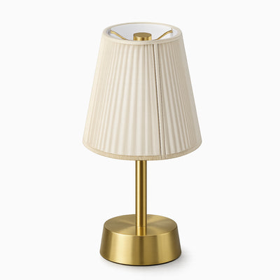 Cordless table lamp with a cotton ivory shade and brass base on a white background