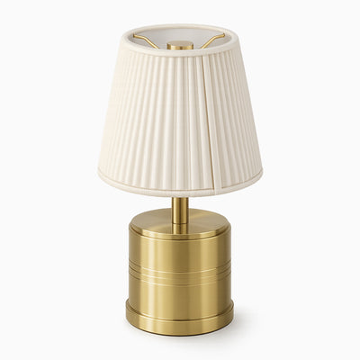 Cordless table lamp with a ivory cotton shade and brass base on a white background