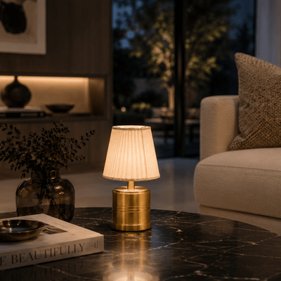 A rechargeable cordless table lamp on a dark marble surface with a blurred background of a living room.