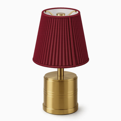 Cordless table lamp with a red cotton shade and brass base on a white background