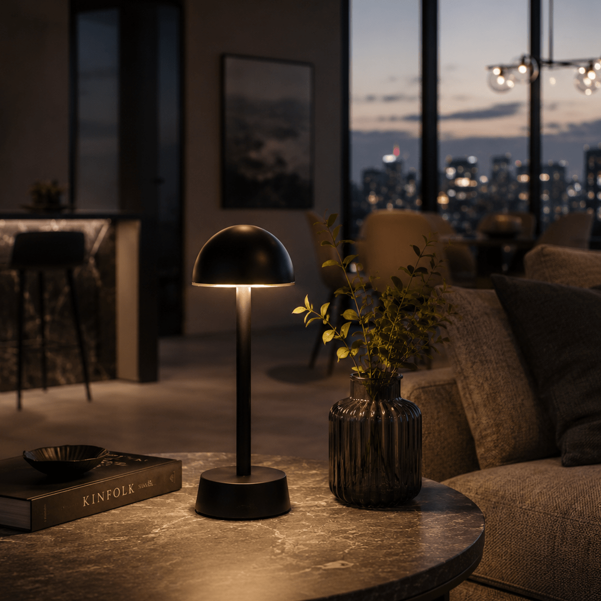 Modern living room with a rechargeable table lamp, book, and vase in a cozy setting.