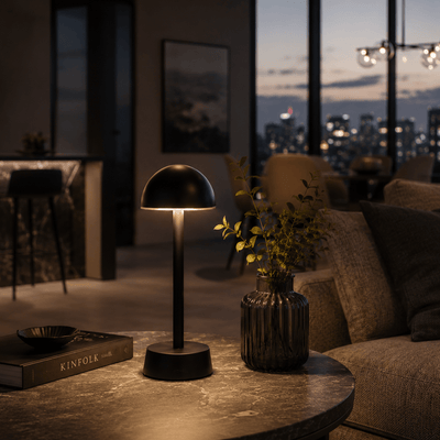 Modern living room with a rechargeable table lamp, book, and vase in a cozy setting.
