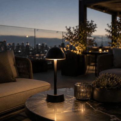 Modern outdoor rechargeable table lamp on a marble surface with cityscape in the background