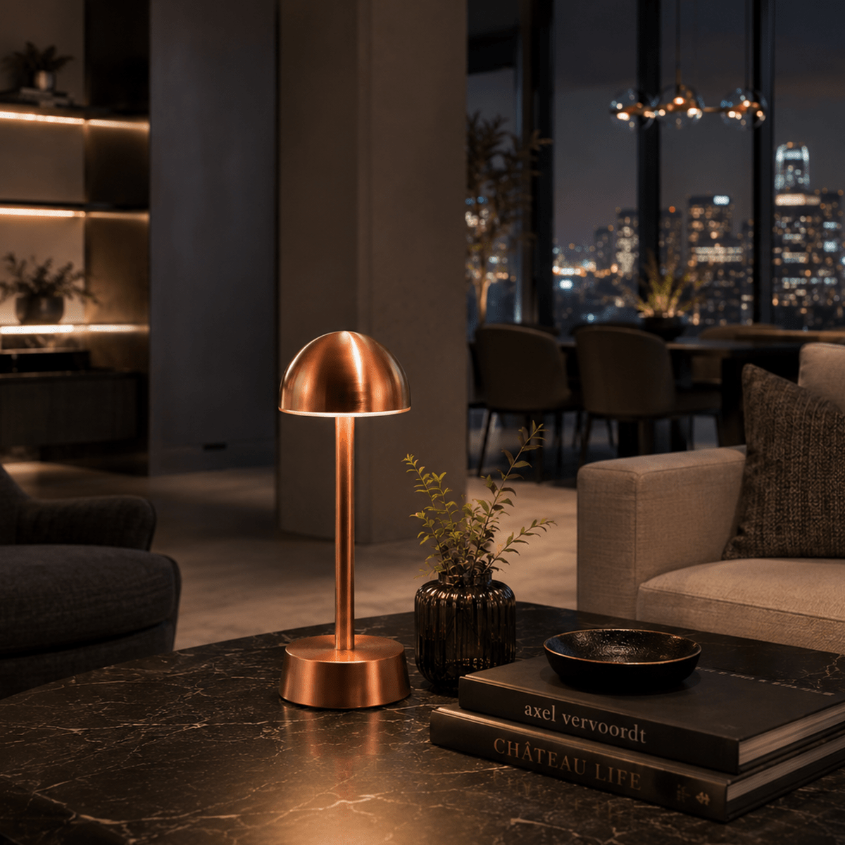 Copper rechargeable table lamp on a dark marble surface with a cityscape view in the background